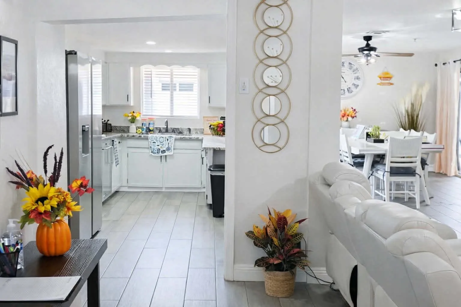 A view through Latham from the entry hall into the white kitchen, with the dining table visible beyond